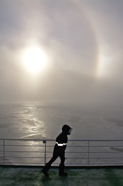 A sharp, cold wind blows over Polarstern. A halo shines through the fog. ©Reese/Winkelmann